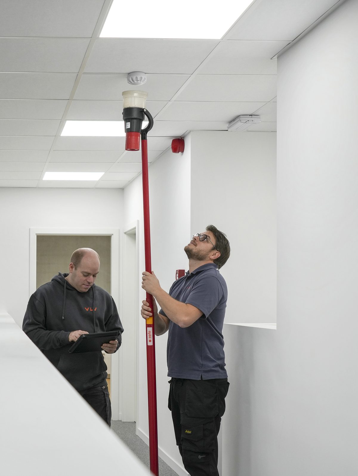 Een VLV-technicus test een installatie in een gebouw